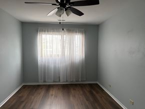 Gurnee apartment for rent - A room with a ceiling fan and a window with curtains.