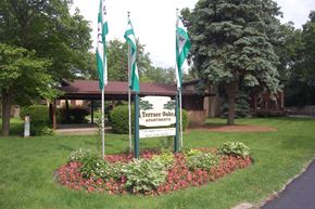 Lake Bluff apartment for rent - a round flower bed with three flags in front of a sign