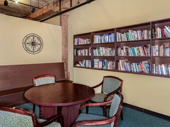 A table and chairs in a room with a bookshelf