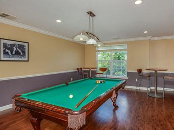 A pool table in a room with a window