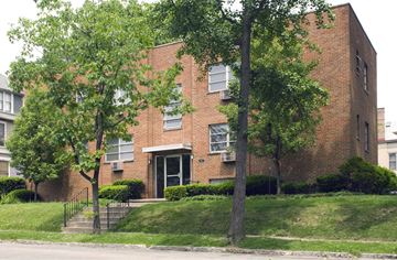 Cincinnati apartment for rent - A red brick building with a black gate in front.
