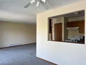 Grayslake apartment for rent - A room with a ceiling fan and a window with a view of a kitchen.