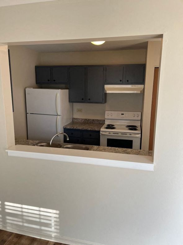Grayslake apartment for rent - A kitchen with a white fridge and stove top oven.