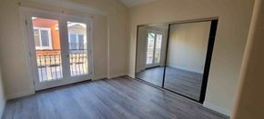 Hawthorne apartment for rent - an empty living room with a mirror and a door to a balcony
