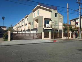 Hawthorne apartment for rent - a row of houses on a street corner with a fence