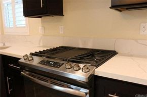 Hawthorne apartment for rent - A stainless steel gas stove with four burners is installed in a kitchen.
