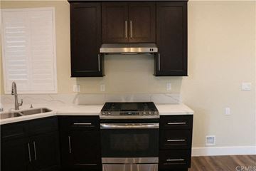 Hawthorne apartment for rent - A kitchen with black cabinets and a stainless steel stove top.