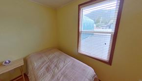Sitka house for rent - a small bedroom with a bed and a window