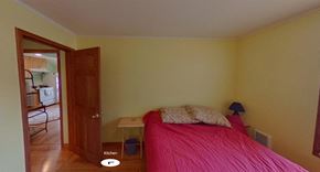 Sitka house for rent - a bedroom with a bed and a door to a kitchen