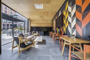 Denver apartment for rent - a dining room with tables and chairs and a wall with geometric patterns