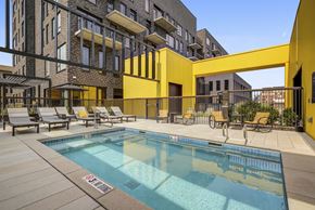 Denver apartment for rent - the pool area of a building with a swimming pool and lounge chairs