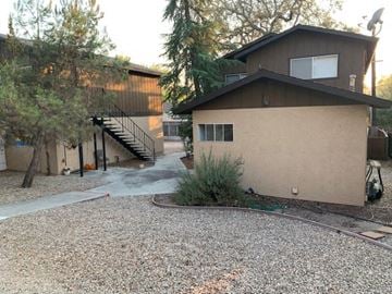 Atascadero apartment for rent - A house with a gravel driveway and a tree in front.