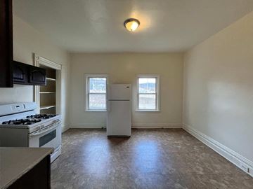 Dravosburg apartment for rent - A kitchen with a stove top oven and a refrigerator.