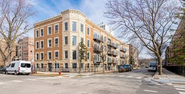 Chicago apartment for rent - A street view of a large brick building with a white van parked in front.