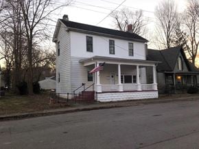Morrow apartment for rent - A white house with a red and blue American flag on the front porch.