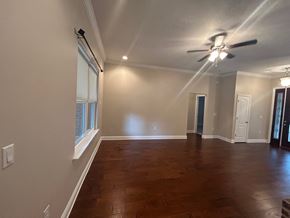 Crestview house for rent - A room with a ceiling fan and wooden flooring.