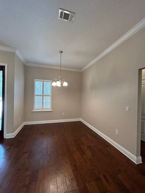 Crestview house for rent - A room with wooden floors and a chandelier.