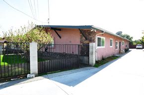 Pomona apartment for rent - a pink house with a fence and a driveway