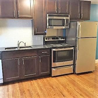 Saint Louis apartment for rent - A kitchen with a stove, oven, microwave, and refrigerator.