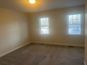 Wilson apartment for rent - A room with a carpeted floor and two windows.