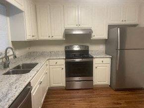 Wilson apartment for rent - A kitchen with white cabinets and a stainless steel refrigerator.