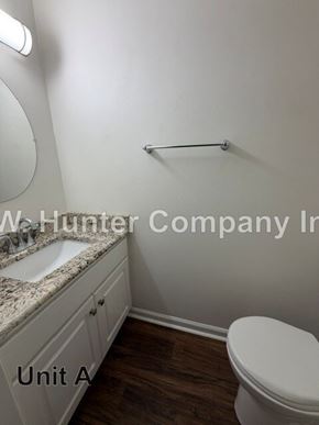 Wilson apartment for rent - A white toilet in a bathroom with a sink and a mirror.