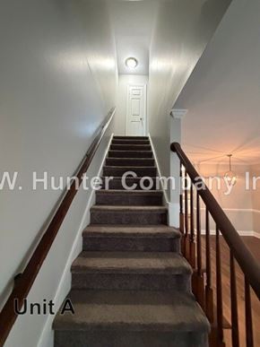 Wilson apartment for rent - A staircase with a carpeted runner and wooden handrails.