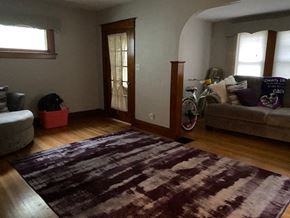 Buffalo apartment for rent - A room with a rug on the floor and a bicycle leaning against the wall.