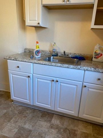 Buffalo apartment for rent - a kitchen with white cabinets and a sink