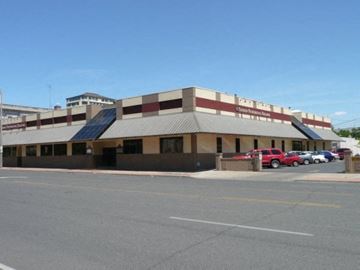 Yakima apartment for rent - A parking lot in front of a building with a red car parked.
