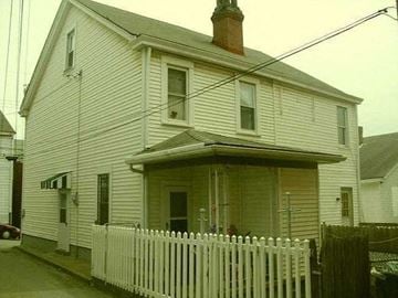 Sharpsburg apartment for rent - A white house with a brown roof and a white picket fence.
