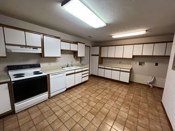 Fremont apartment for rent - A kitchen with white cabinets and a black stove top oven.