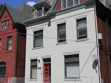 Pittsburgh apartment for rent - A white building with a red door and windows.