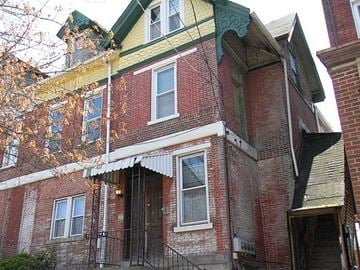 Pittsburgh apartment for rent - A red brick building with a green roof and a white awning.