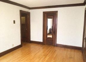Milwaukee apartment for rent - an empty living room with a wooden floor and a door