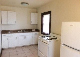 Milwaukee apartment for rent - a white kitchen with a stove and a refrigerator