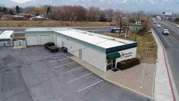 Layton apartment for rent - A parking lot with a building and a mountain in the background.