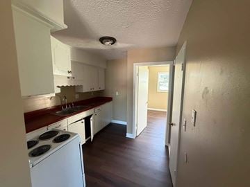 Fremont apartment for rent - A kitchen with white cabinets and a red countertop.