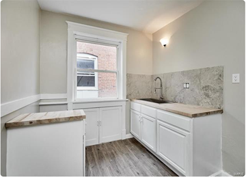 St. Louis apartment for rent - a white kitchen with white cabinets and a window