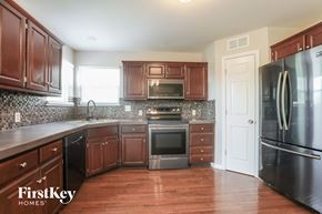 Belton house for rent - a kitchen with dark wood cabinets and stainless steel appliances