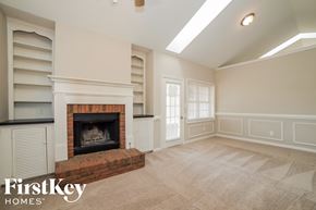 Dallas house for rent - an empty living room with a fireplace and shelves