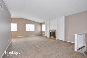 Lake Saint Louis house for rent - A spacious room with a fireplace and a carpeted floor.