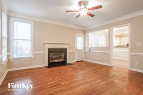 Greensboro house for rent - A spacious room with a fireplace and a ceiling fan.