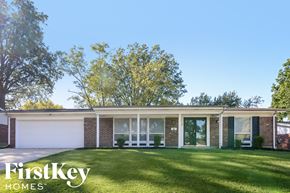 Florissant house for rent - A house with a white garage door and a brick wall.