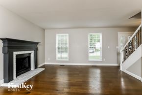 O'fallon house for rent - A spacious living room with a fireplace and wooden floors.