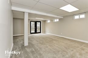 O'fallon house for rent - A spacious room with a door at the end and a window on the wall.
