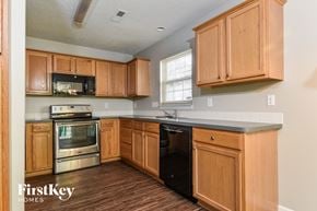 Browns Summit house for rent - a kitchen with wooden cabinets and a black counter top and a stove and microwave