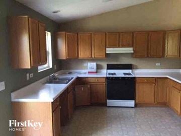 Lake In The Hills house for rent - A kitchen with wooden cabinets and a black dishwasher.