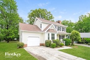 Greensboro house for rent - a white house with a driveway and a white garage door