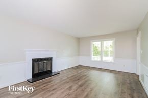 Greensboro house for rent - the living room of a home with a fireplace and wooden floors